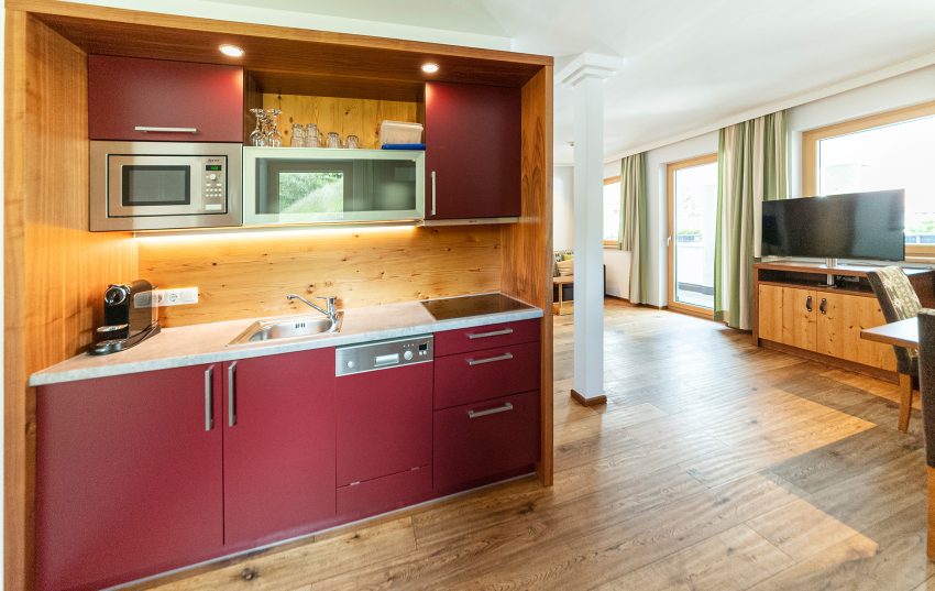 Foto: Rote Küchenzeile im Appartement Haus Ihrer Ferienwohnung in Serfaus Fiss Ladis Tirol im Familienurlaub.